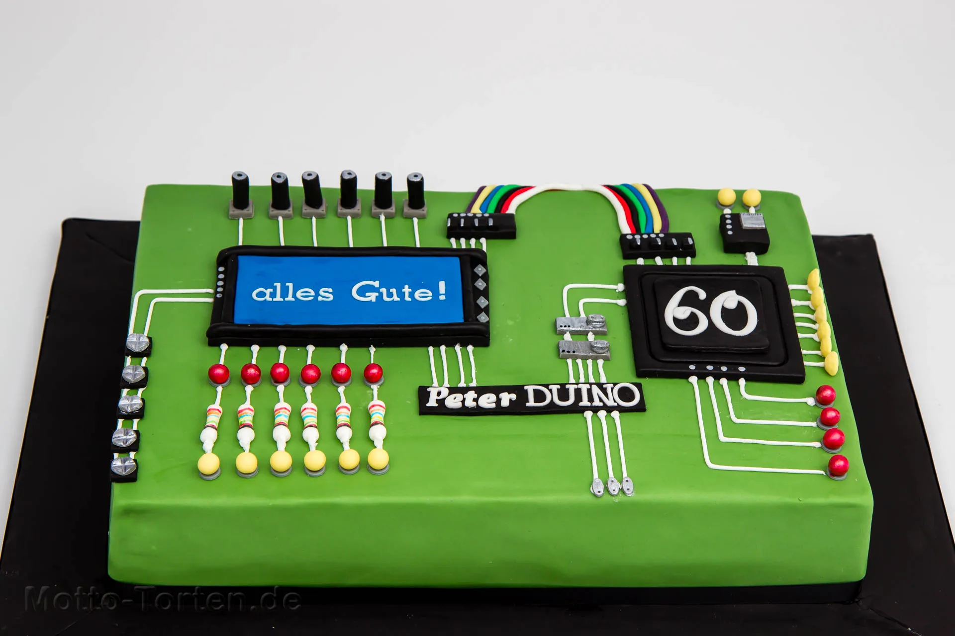 Firmentorte in Form einer grünen Platine mit elektronischen Bauteilen aus Fondant