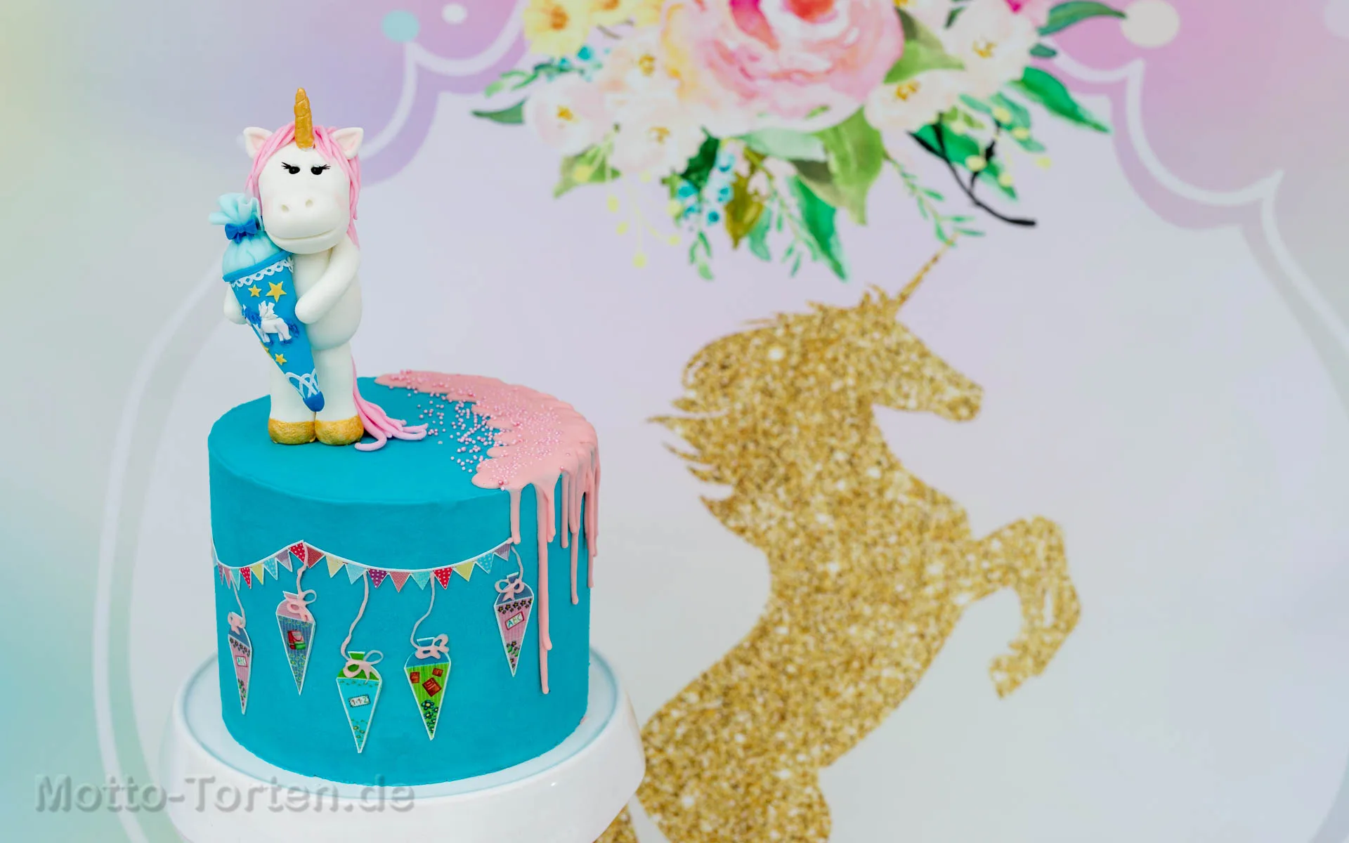 Einschulungstorte mit Einhorn: Ganache in Regenbogenfarben, dazu Schultüte und Schulsachen aus Fondant