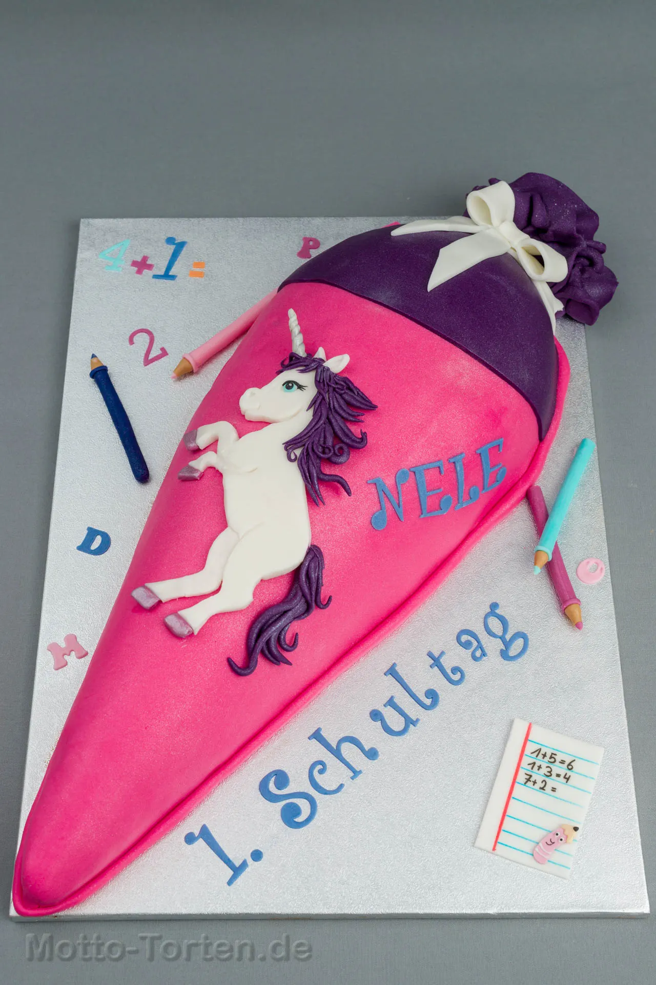 Schultüte als Torte in Pink und Violett mit einem weißen Einhorn aus Fondant und dem Namen Nele