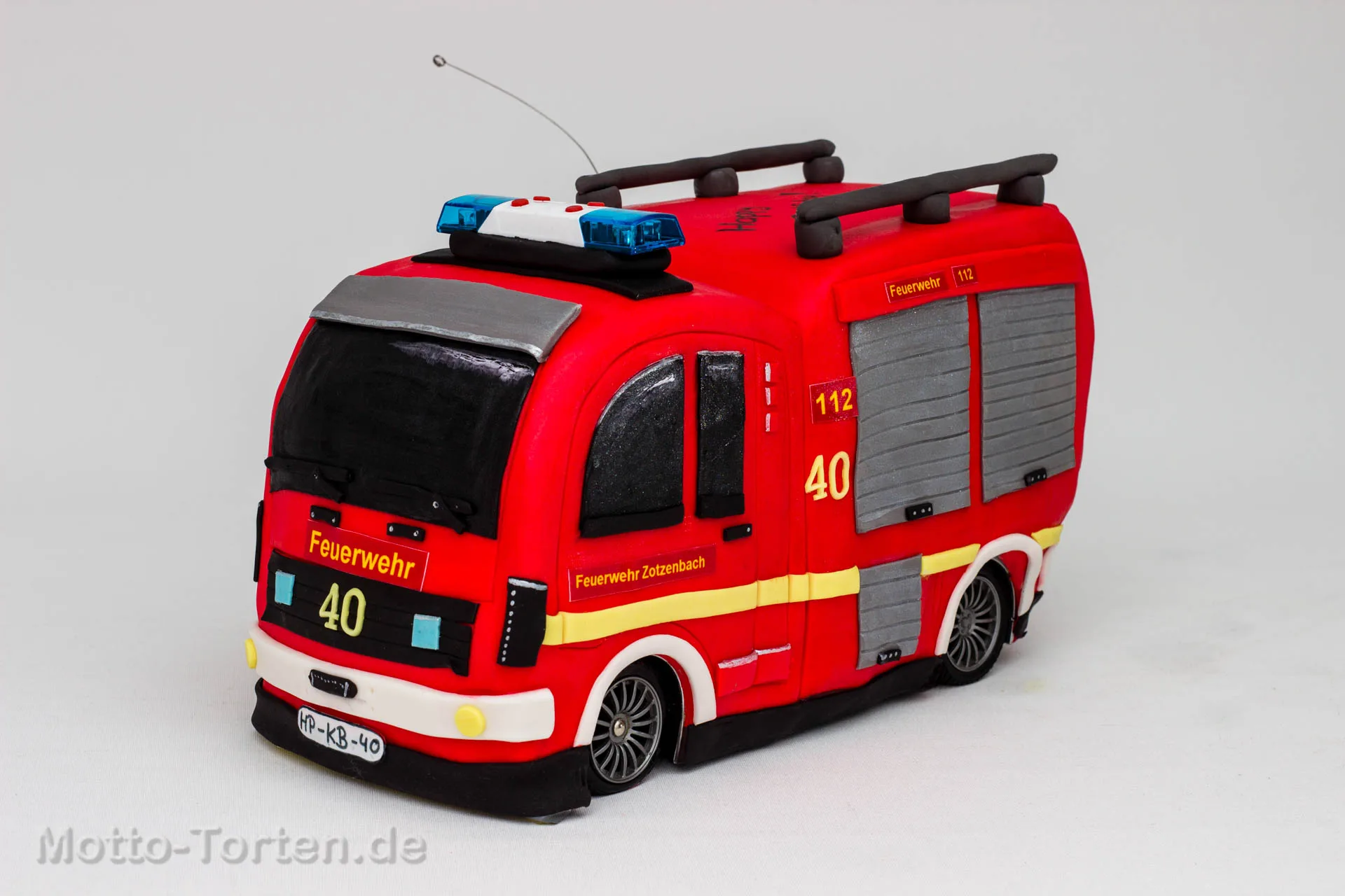 Torte in Form eines roten Feuerwehrautos mit Blaulicht, Leiter auf dem Dach und dem Schriftzug Feuerwehr Zotzenbach
