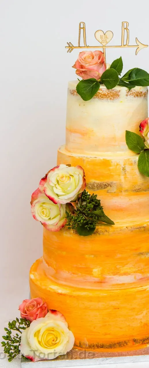 Vierstöckige Hochzeitstorte in Buttercreme mit Farbverlauf von Apricot zu Creme, dekoriert mit echten Rosen und einem hölzernen Tortenaufsatz