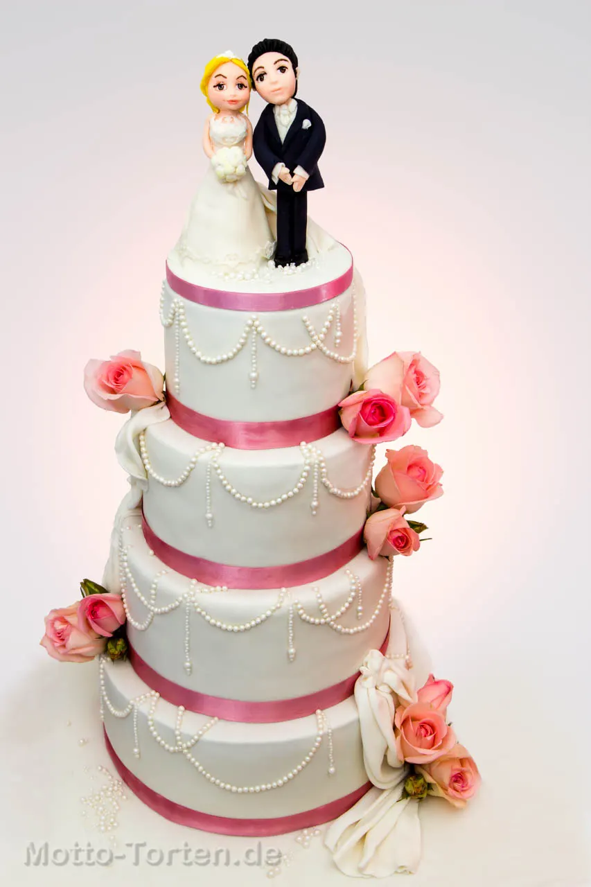 Vierstöckige Hochzeitstorte in Creme mit aufgelegten Perlenketten, altrosa Satinbändern, echten Rosen und einem handmodellierten Brautpaar obenauf