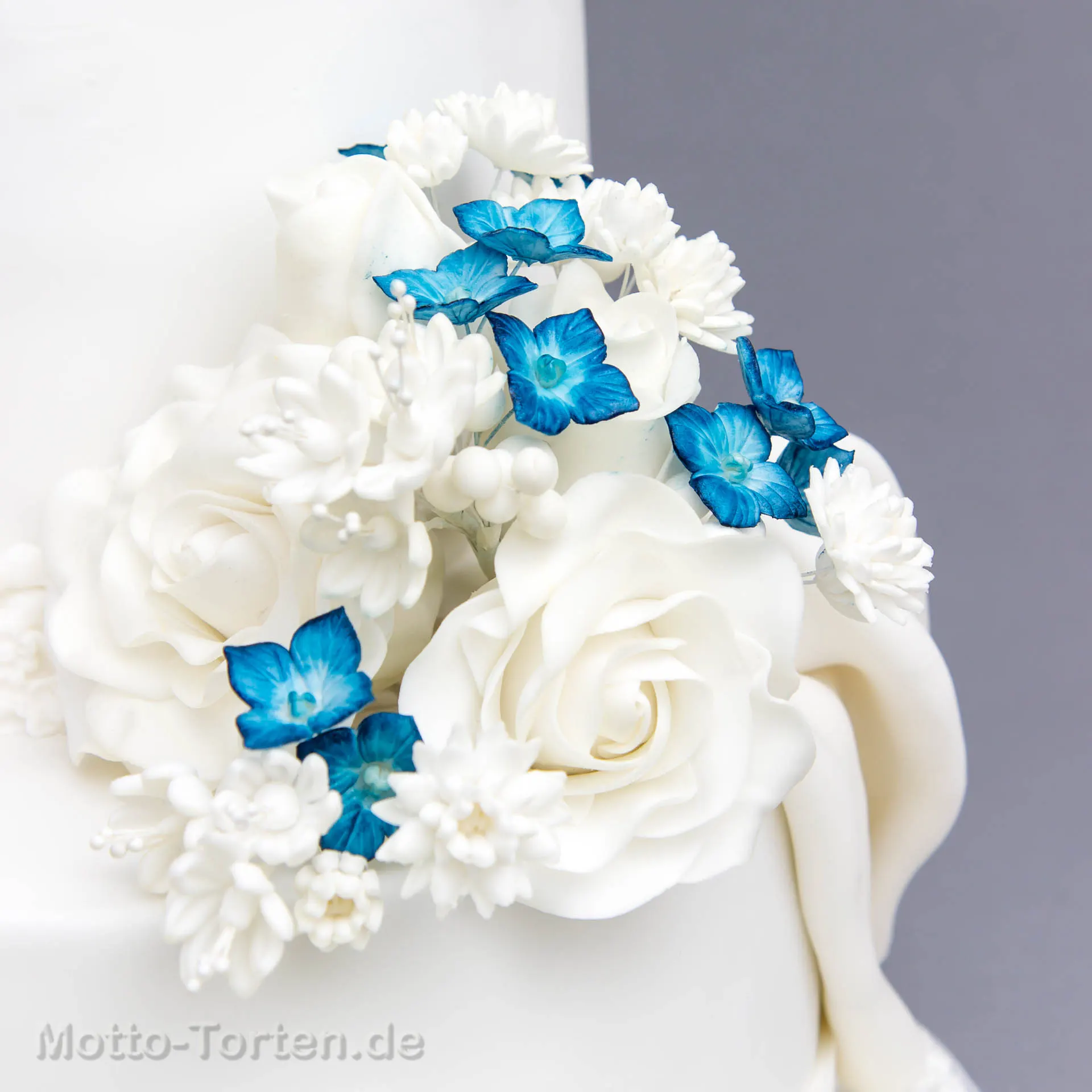 Hochzeitstorte mit zwei Herzen in einem Meer aus Zuckerblüten