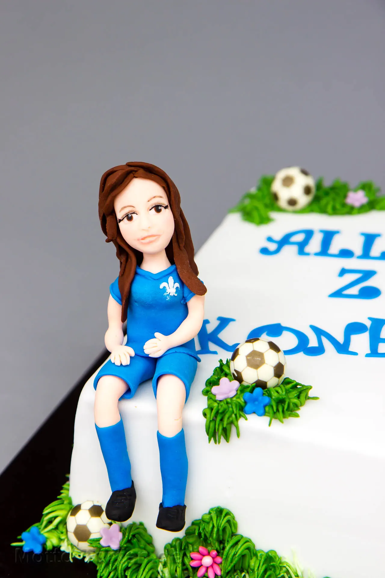 Handmodellierte Fondantfigur eines Mädchens im Fußballtrikot auf einer Konfirmationstorte