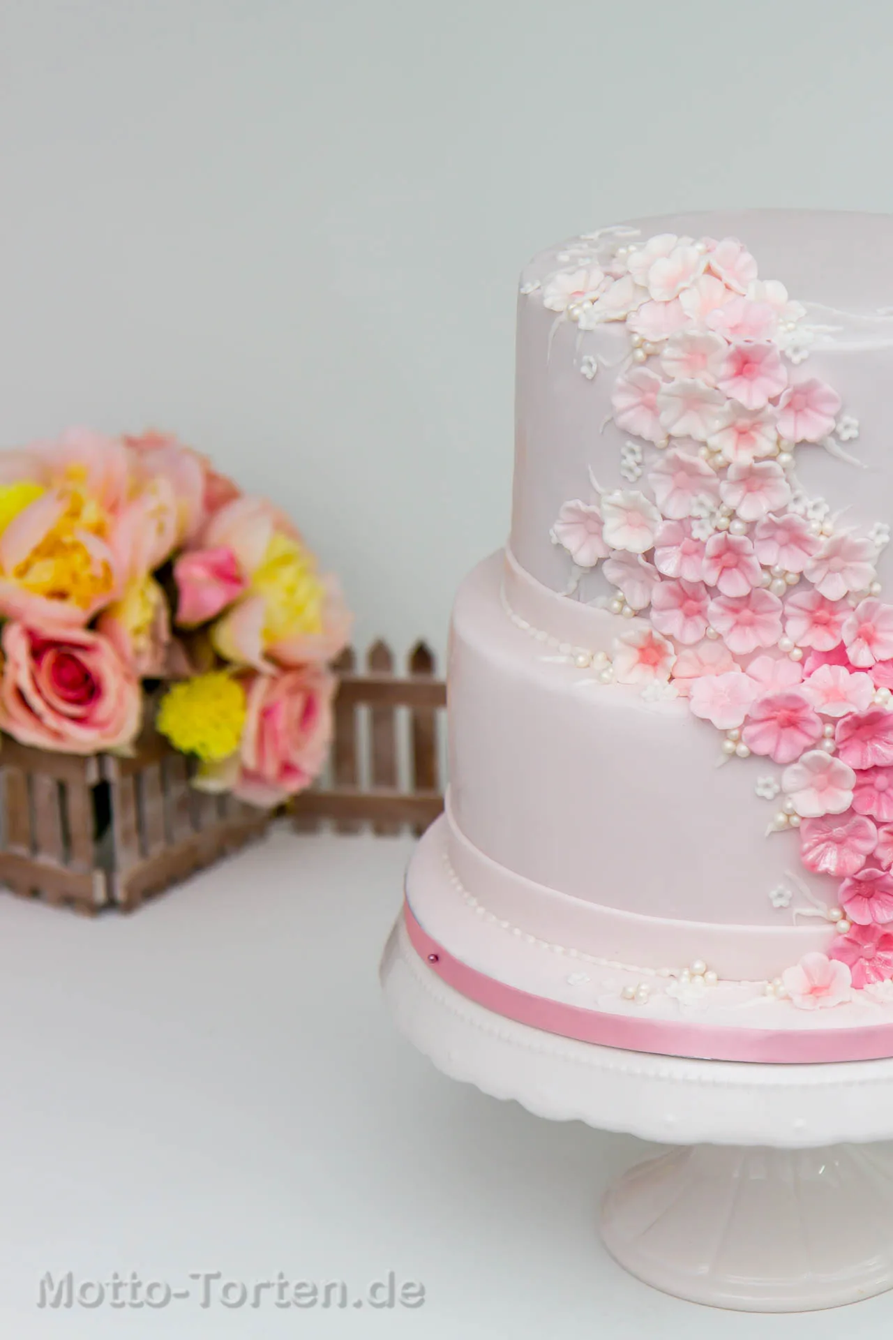 Zweistöckige Konfirmationstorte in Rosa mit handmodellierten Blüten