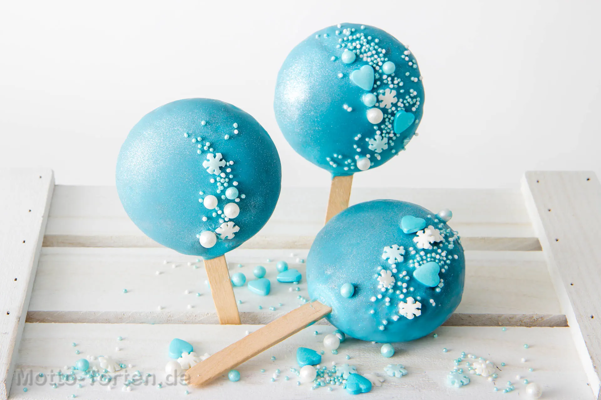 Winterliche Kuchen am Stiel mit eisblauer Glasur, Schneeflocken und Zuckerperlen