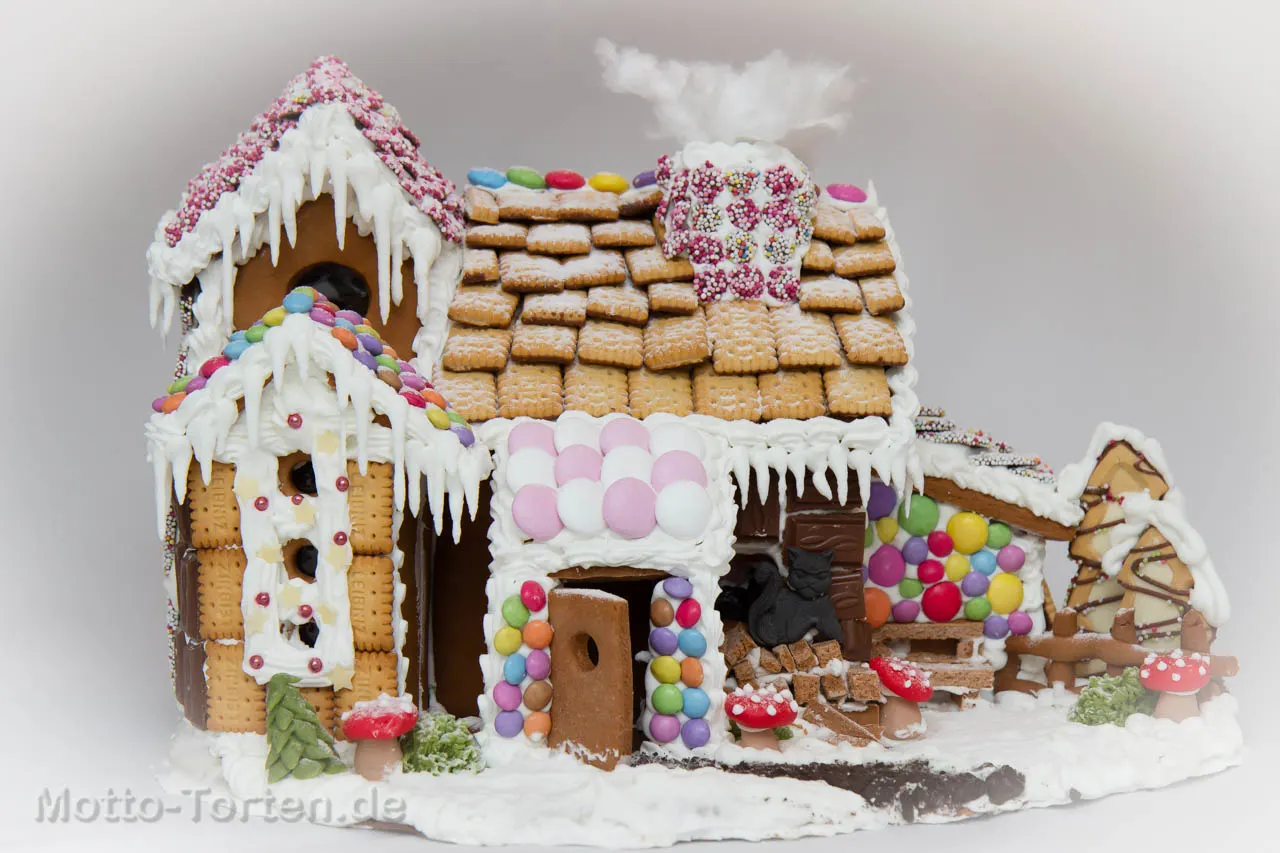 Lebkuchenhaus mit Keksdach, bunten Schokolinsen und Eiszapfen aus Zuckerguss