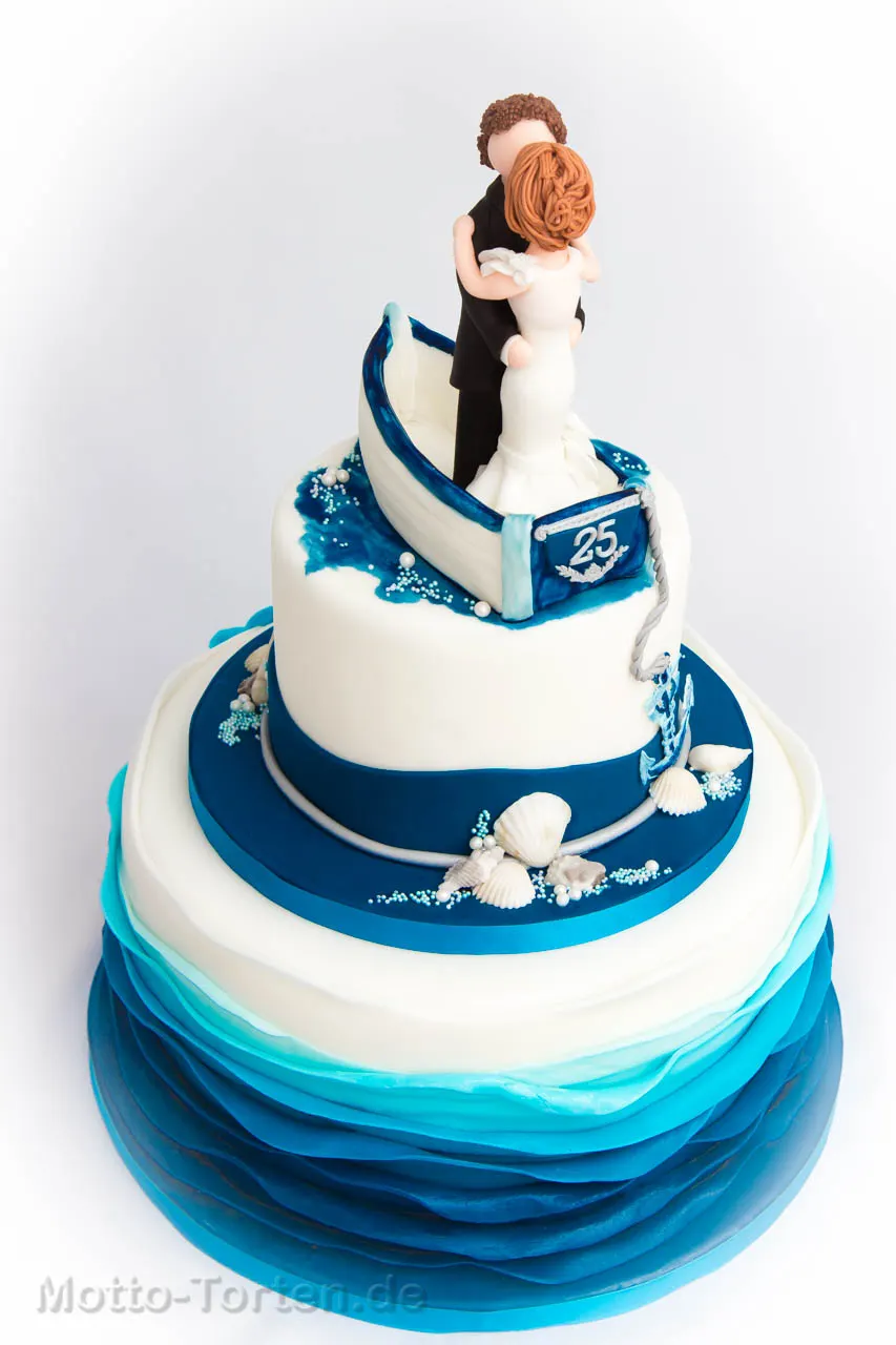 Dreistöckige Torte zur Silberhochzeit mit Meer aus blauen Fondantrüschen, Muscheln, Anker und Tau, oben ein Paar in einem Boot mit der Zahl 25