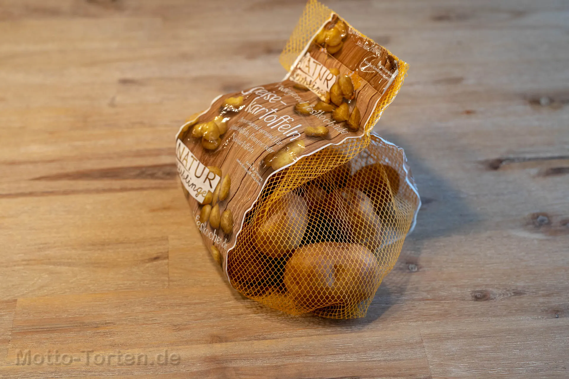 Marzipankartoffeln, die täuschend echt wie Speisekartoffeln aussehen, verpackt in einem originalen Kartoffelnetz