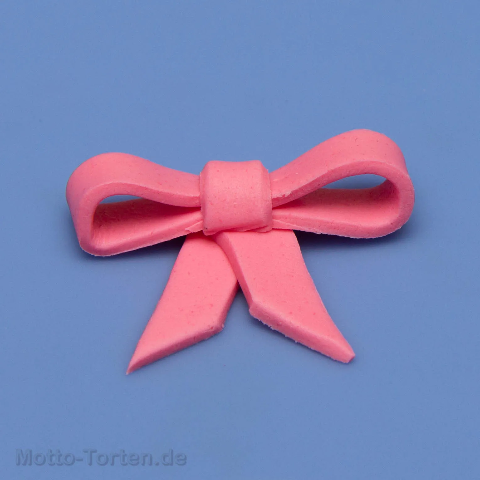 Fertige Schleife aus hellem Fondant, mit zwei Bändern und Mittelstück