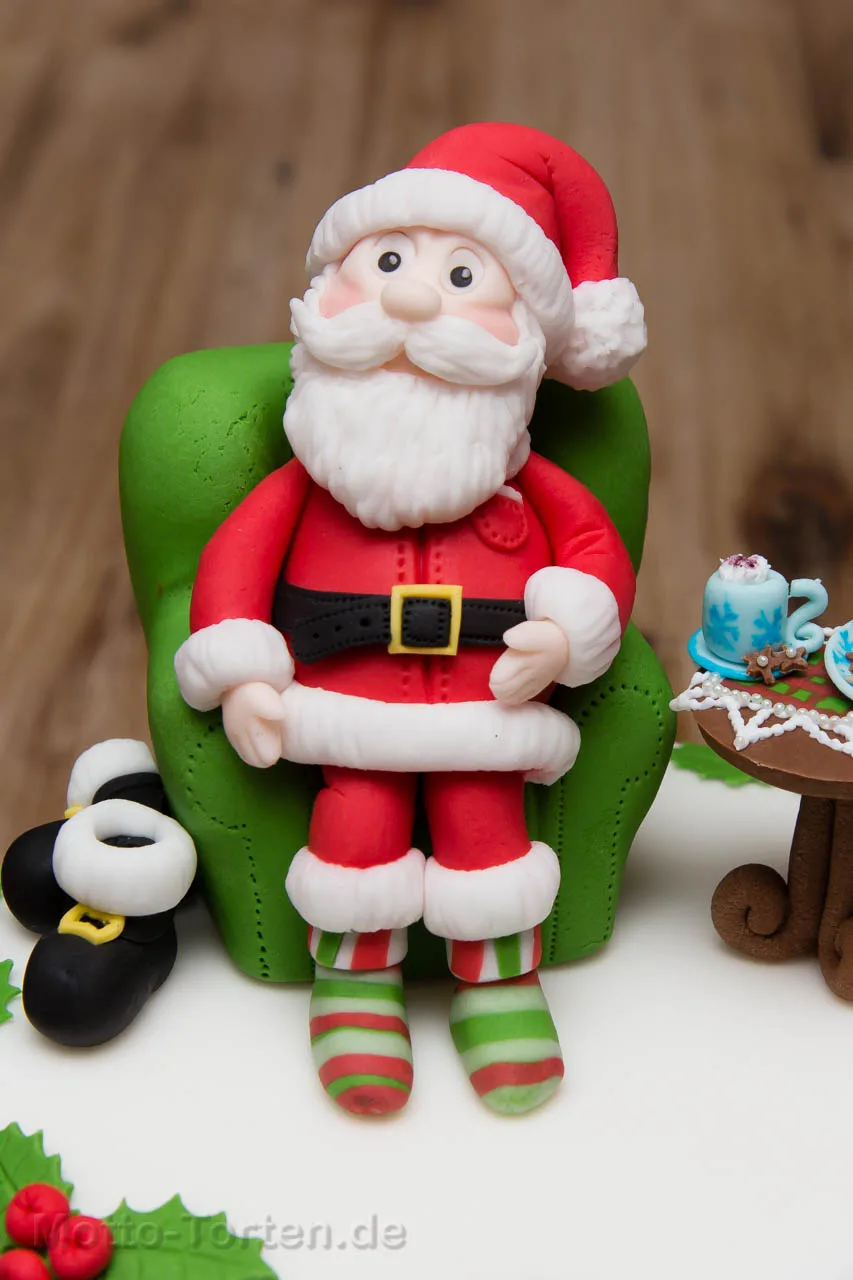 Detail der Weihnachtstorte: modellierter Weihnachtsmann im grünen Sessel, daneben seine Stiefel und ein gedecktes Tischchen