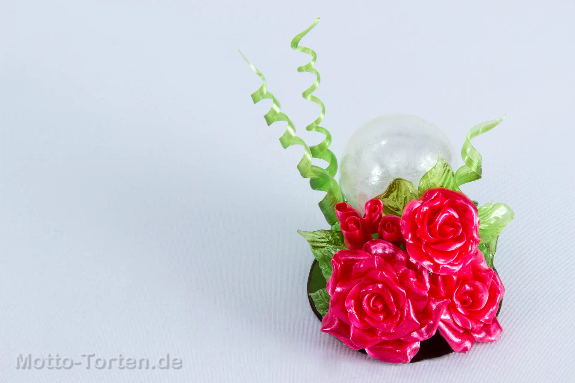 Schaustück aus gezogenem Zucker: pinkfarbene Rosen und Knospen mit grünen Blättern und Spiralen vor einer geblasenen Zuckerkugel – Ansicht 2