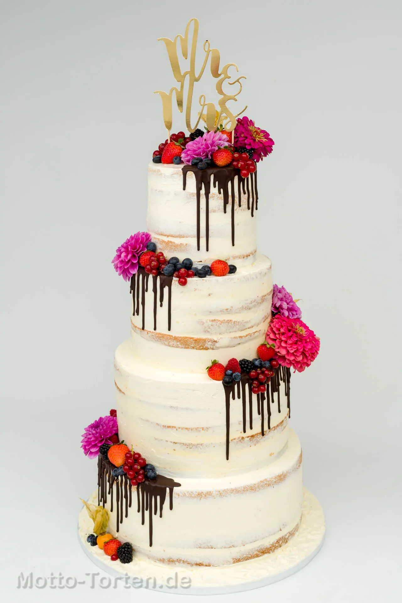 Hochzeitstorte mit vielen frischen Früchten und Drip
