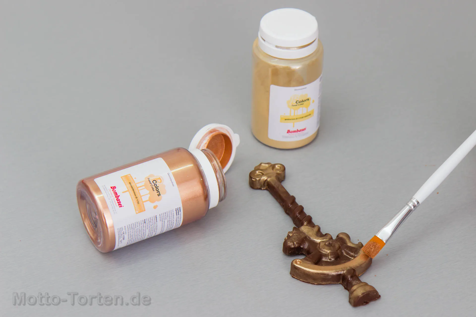 Ein Pferdchen wird mit Puderfarbe in Bronze und Gold bepinselt
