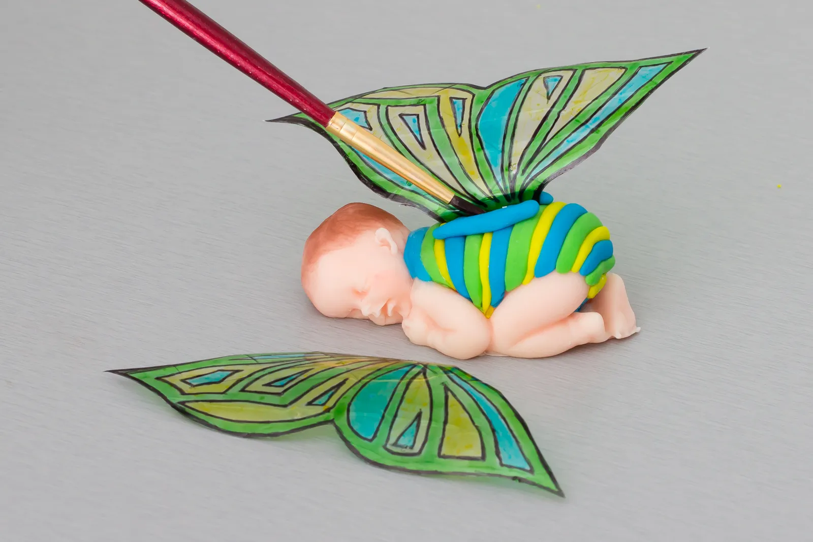 Zuckerkleber wird mit dem Pinsel auf den Rücken des Babys aufgetragen