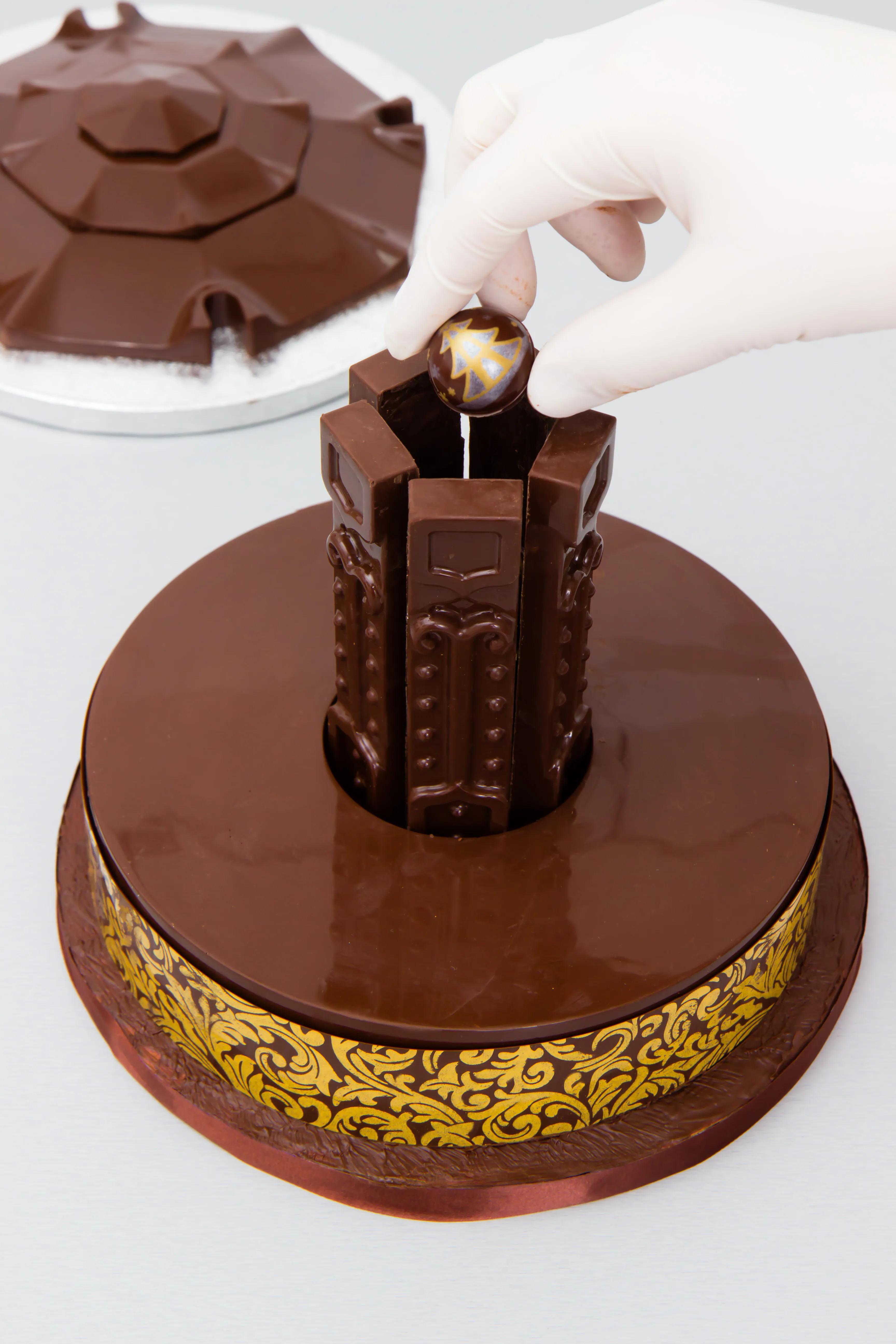Eine Praline wird in die Mitte zwischen die Träger gesetzt