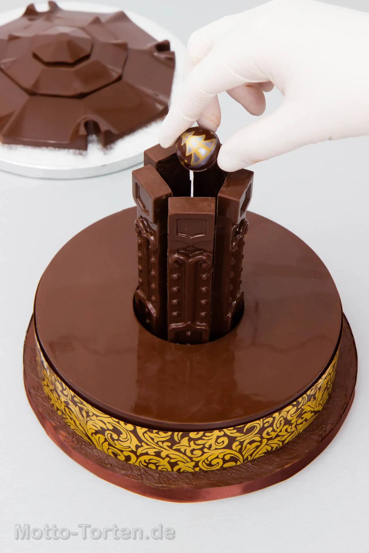 Eine Praline wird in die Mitte zwischen die Träger gesetzt