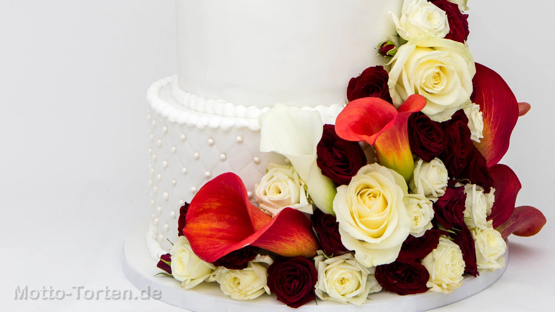 Hochzeitstorte mit echten frischen Blumen aus Rosen und Callas dekoriert